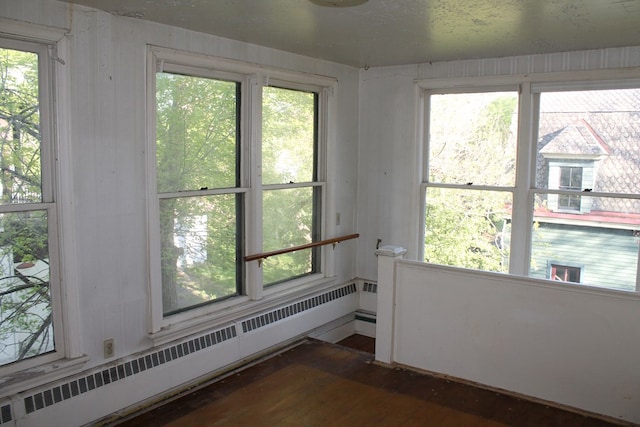 interior space with radiator, dark hardwood / wood-style flooring, and a healthy amount of sunlight