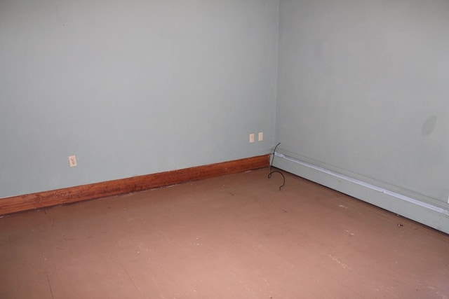 unfurnished room with a baseboard heating unit