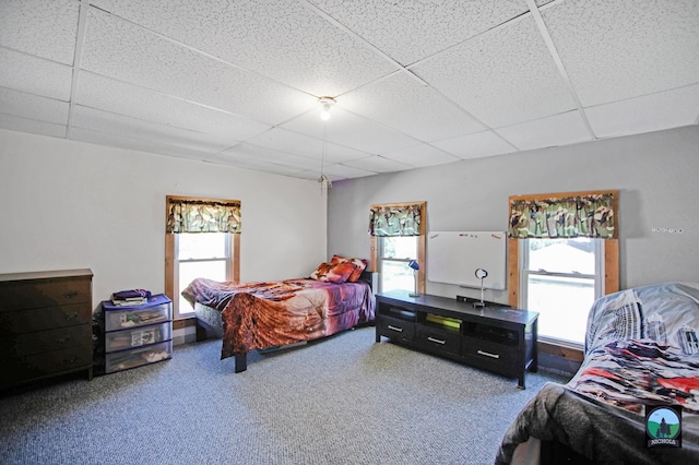 carpeted bedroom with a drop ceiling