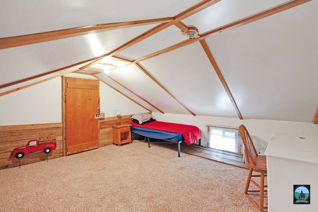 carpeted bedroom featuring wooden walls and lofted ceiling