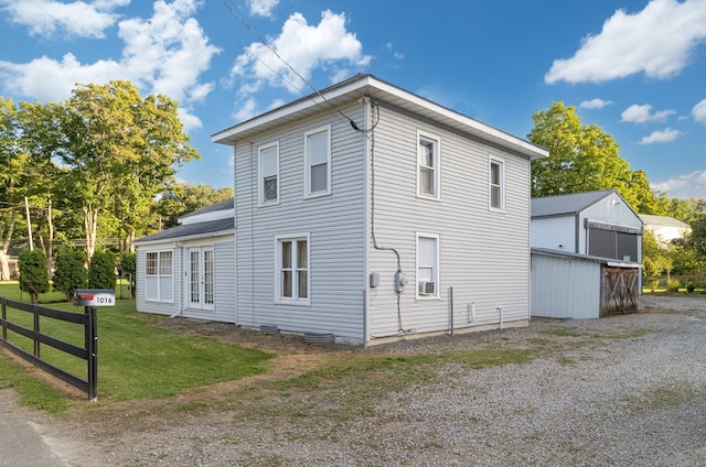 view of side of property with a yard and an outbuilding