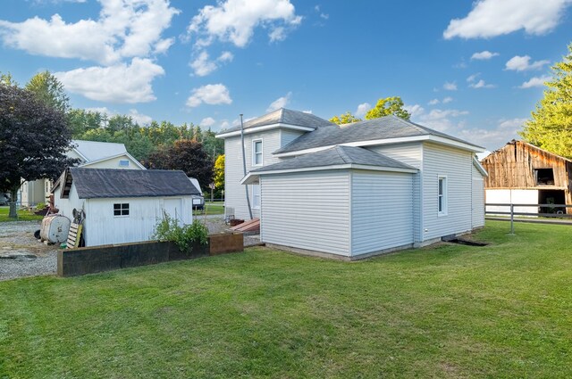 exterior space featuring a lawn and a storage unit