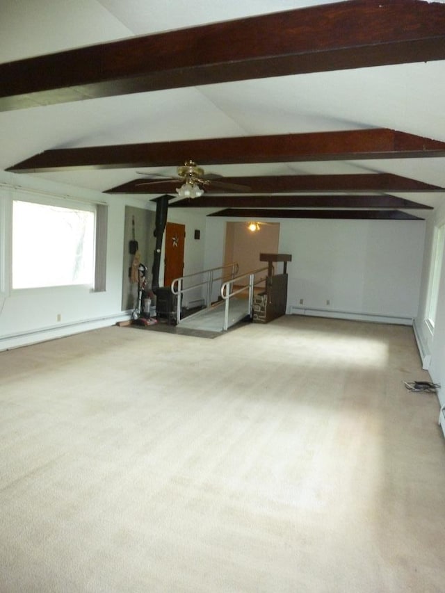 unfurnished living room featuring a baseboard heating unit and vaulted ceiling with beams