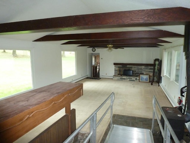 unfurnished living room with a baseboard heating unit, a stone fireplace, beamed ceiling, and ceiling fan