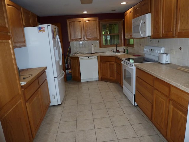 kitchen with tasteful backsplash, sink, white appliances, and light tile patterned flooring