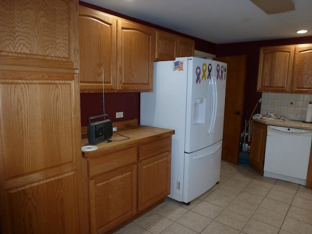 kitchen with tasteful backsplash, white appliances, and light tile patterned flooring