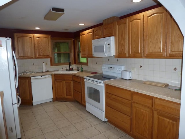 kitchen featuring sink, white appliances, light tile patterned floors, and backsplash