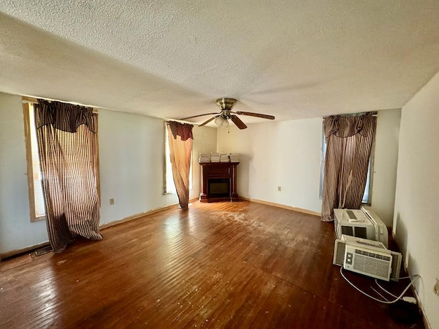 unfurnished living room featuring a fireplace, a textured ceiling, dark hardwood / wood-style floors, and ceiling fan