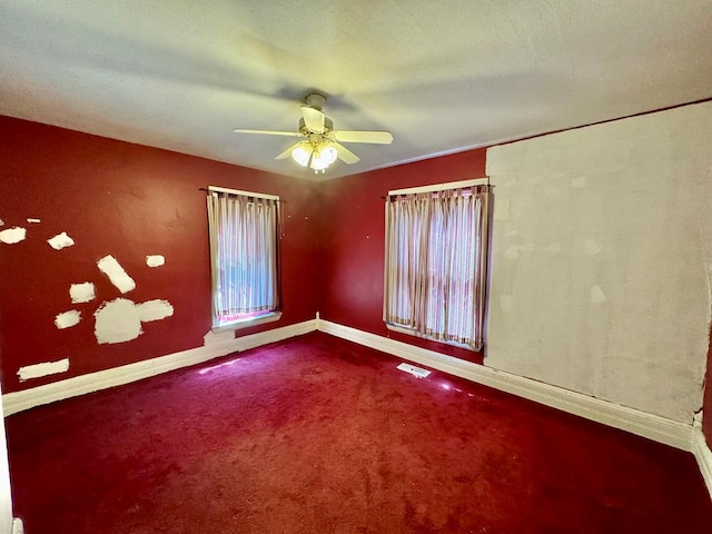 empty room featuring ceiling fan and carpet