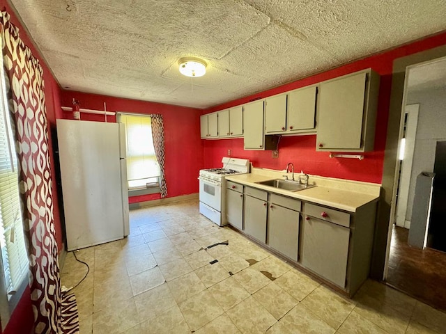 kitchen featuring a textured ceiling, white appliances, and sink