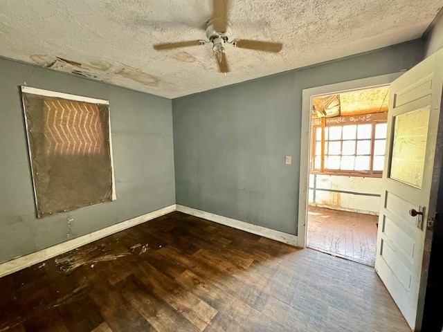 unfurnished room with a textured ceiling, dark hardwood / wood-style floors, and ceiling fan