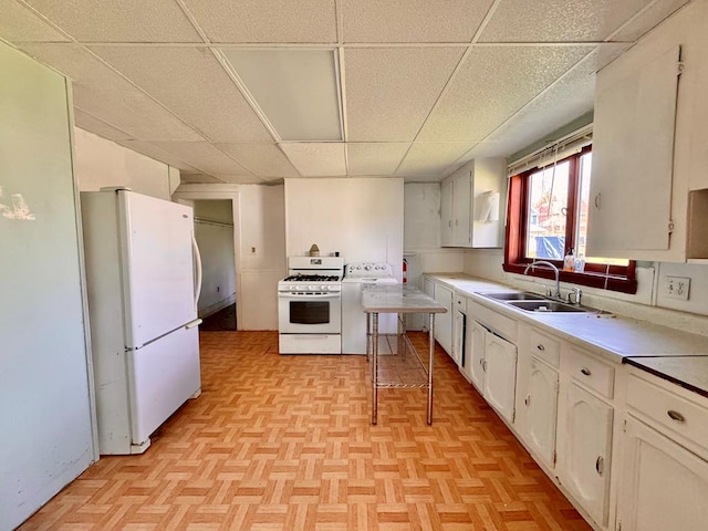 kitchen with sink, white cabinets, white appliances, and light parquet floors