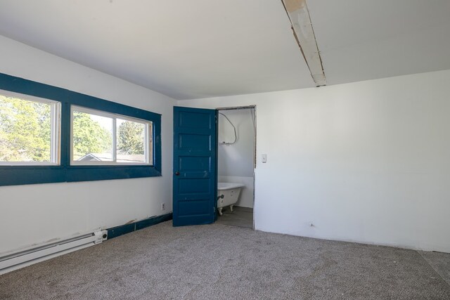 unfurnished bedroom with ensuite bathroom, a baseboard heating unit, and carpet floors