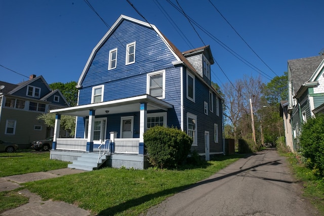 front of property with covered porch and a front yard