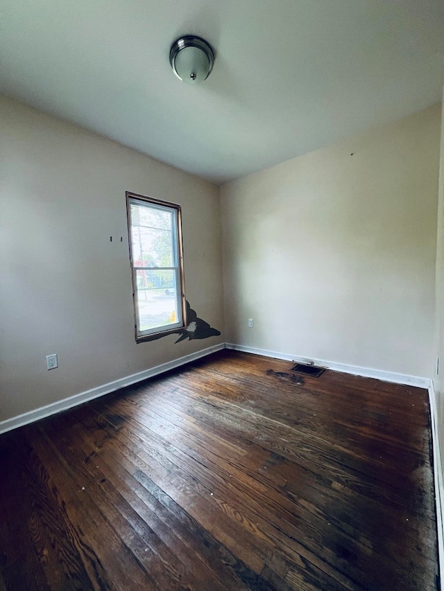 spare room featuring dark wood-type flooring