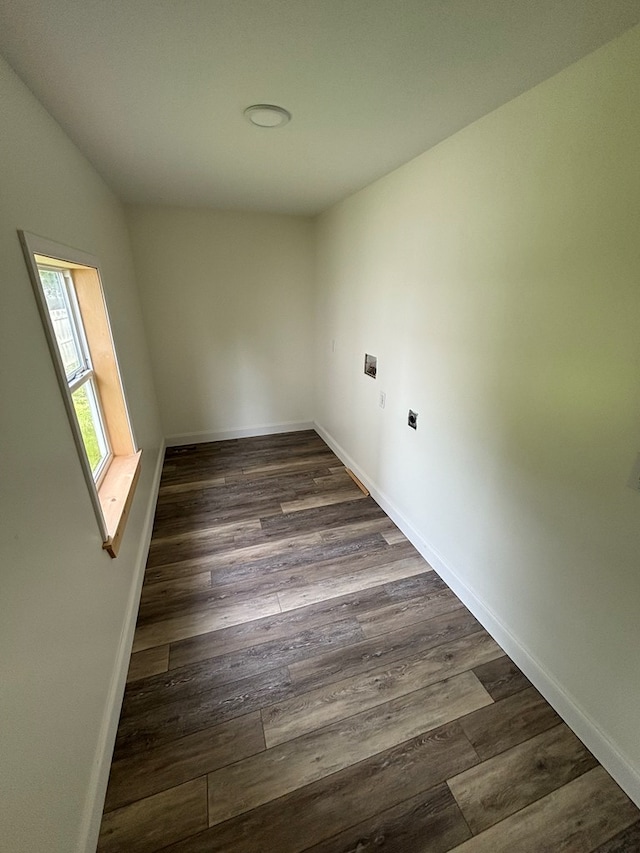 spare room featuring lofted ceiling and dark hardwood / wood-style floors