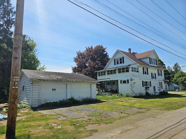 view of side of home with an outbuilding, a garage, and a lawn