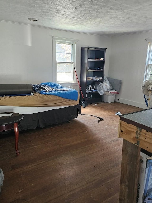 bedroom featuring dark wood-type flooring and a textured ceiling