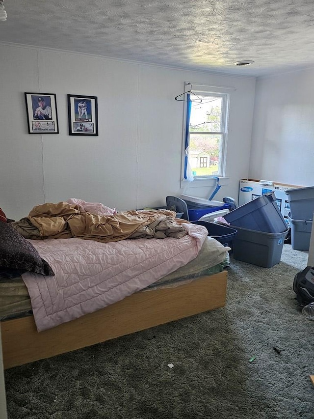 bedroom with a textured ceiling and dark carpet