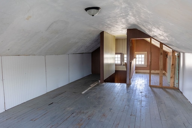 additional living space with light wood-type flooring and vaulted ceiling