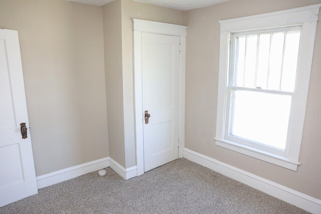 interior space featuring light carpet, a closet, and multiple windows