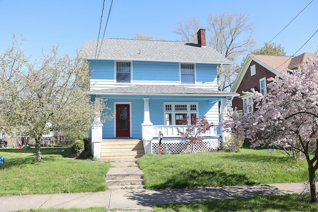 view of property featuring covered porch and a front yard