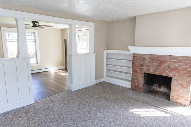 unfurnished living room featuring a textured ceiling, hardwood / wood-style flooring, a brick fireplace, and ceiling fan