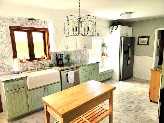 kitchen featuring appliances with stainless steel finishes, decorative light fixtures, plenty of natural light, and sink