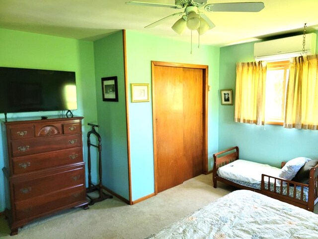 carpeted bedroom with a wall mounted AC, a closet, and ceiling fan