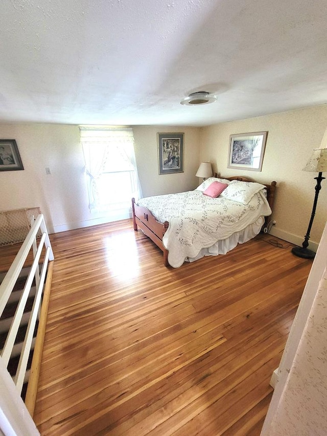 bedroom featuring hardwood / wood-style floors and a textured ceiling