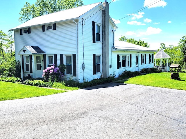 colonial-style house featuring a front lawn