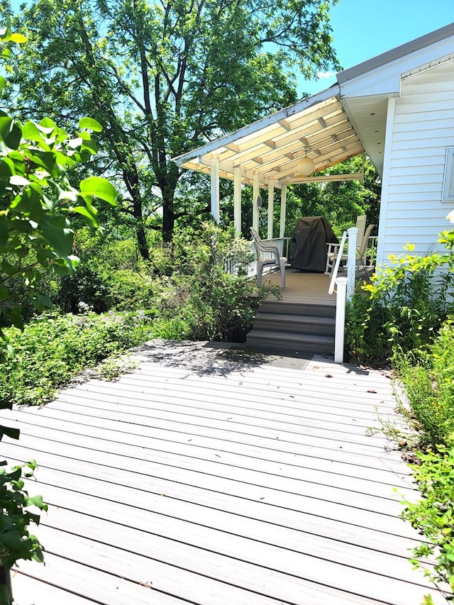 wooden deck featuring a grill