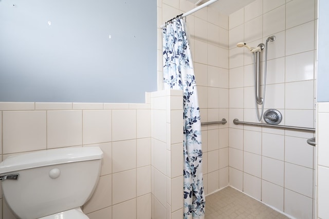 bathroom featuring a shower with curtain, toilet, and tile walls