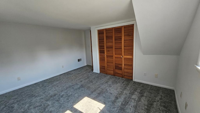 unfurnished bedroom with a closet and dark carpet