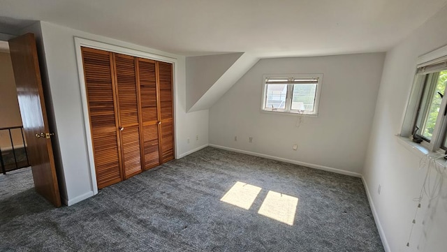 unfurnished bedroom featuring multiple windows, a closet, and dark carpet