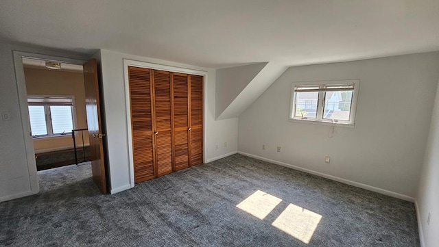 unfurnished bedroom with a closet and dark carpet