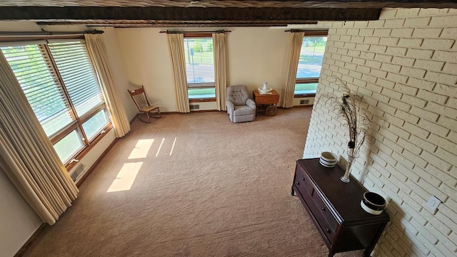 interior space featuring beamed ceiling, brick wall, and light carpet