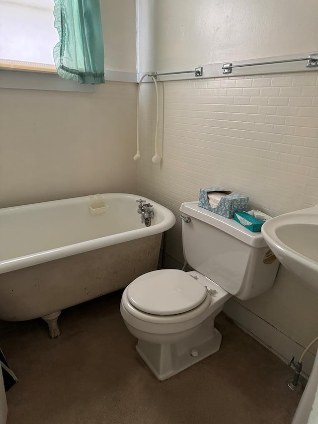 bathroom with a washtub and toilet