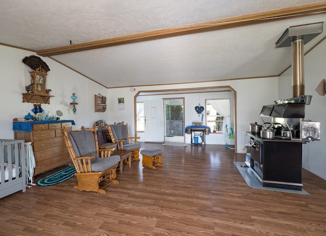 interior space with a textured ceiling, dark hardwood / wood-style flooring, and vaulted ceiling with beams