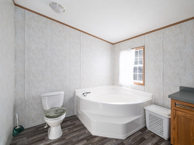 bathroom featuring vanity, a bathing tub, hardwood / wood-style floors, crown molding, and toilet