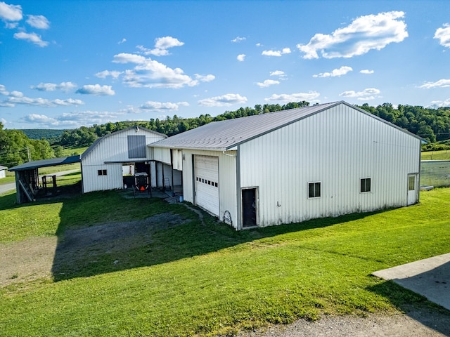 exterior space featuring an outdoor structure, a yard, a carport, and a garage