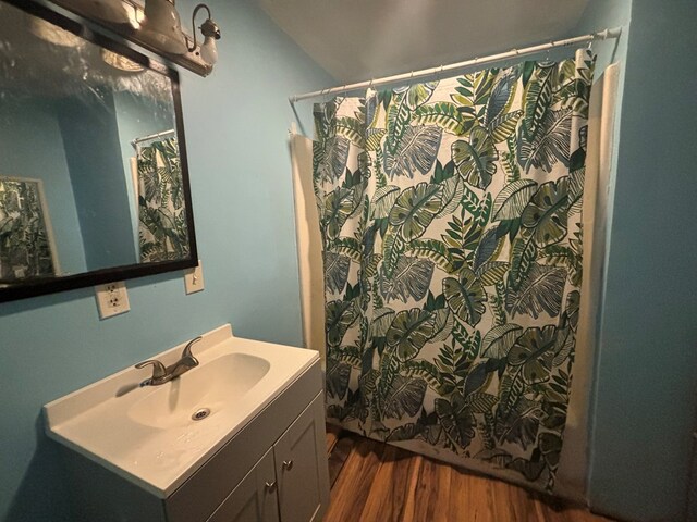 bathroom with vanity, a shower with shower curtain, vaulted ceiling, and wood-type flooring