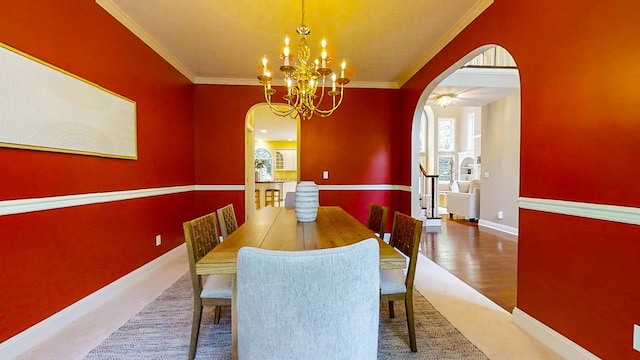 dining space with ornamental molding and a notable chandelier