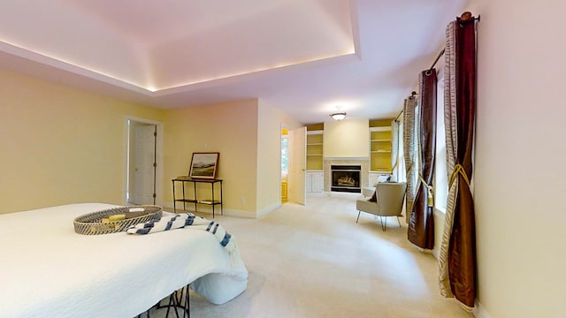 bedroom with light colored carpet and a raised ceiling