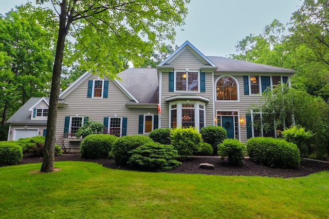 colonial home featuring a garage and a front yard