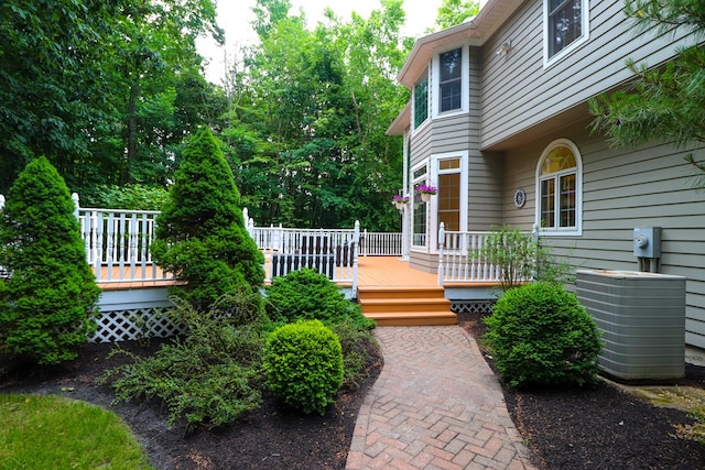 doorway to property with a wooden deck and cooling unit