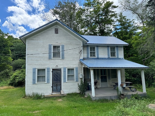 view of front of house with covered porch and a front lawn