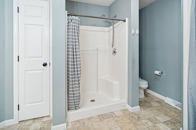 bathroom featuring a shower with curtain and toilet