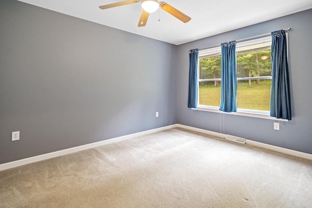 carpeted spare room featuring ceiling fan