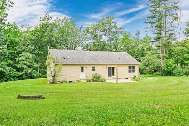 back of property with a yard and a patio